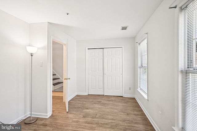 450 Hartford Sq Unit 7, West Chester, PA 19380 - unfurnished bedroom with wood finished floors, multiple windows, and a closet