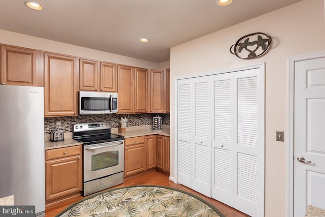 637 Wallingford Rd Unit 202, Bel Air, MD 21014 - kitchen with stainless steel appliances, backsplash, light wood-style floors, light stone counters, and recessed lighting