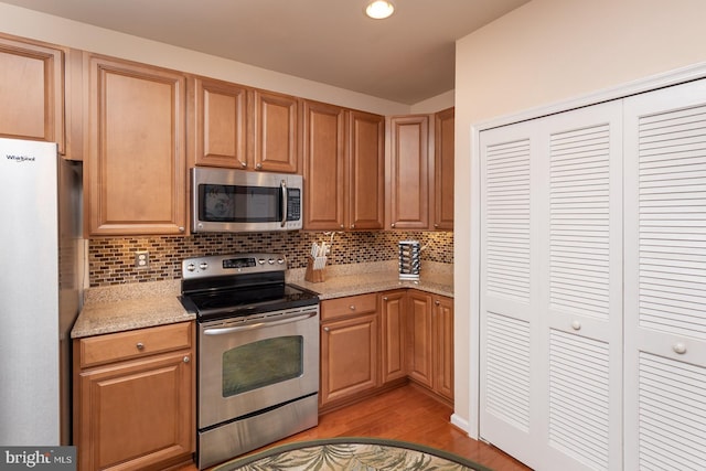 637 Wallingford Rd Unit 202, Bel Air, MD 21014 - kitchen with stainless steel appliances, light wood-type flooring, decorative backsplash, and light stone counters