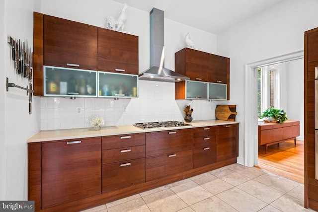 2714 Quebec St NW, Washington, DC 20008 - kitchen featuring wall chimney range hood, stainless steel gas cooktop, decorative backsplash, and light countertops