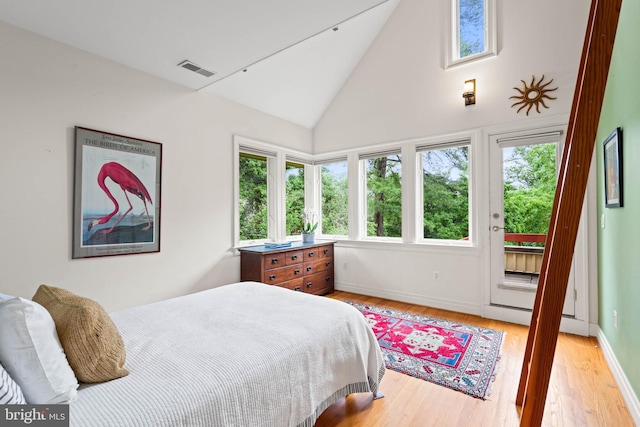 2714 Quebec St NW, Washington, DC 20008 - bedroom with access to exterior, light wood-type flooring, multiple windows, and high vaulted ceiling
