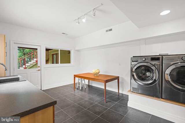 2714 Quebec St NW, Washington, DC 20008 - laundry room with washer and clothes dryer, rail lighting, and dark tile patterned floors