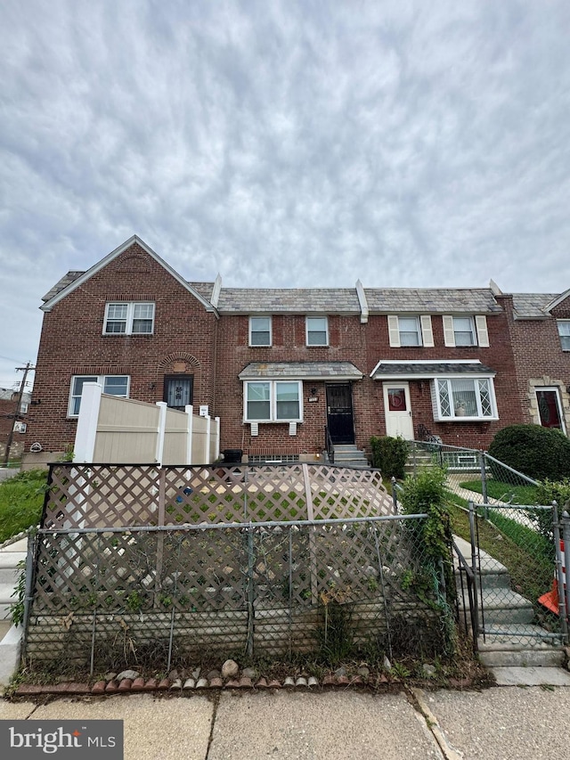 7553 Gilbert St, Philadelphia, PA 19150 - view of property featuring a fenced front yard, brick siding, and a gate