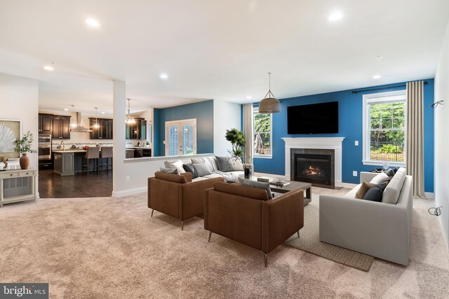 8266 Saint Francis Dr, Severn, MD 21144 - living room featuring recessed lighting, plenty of natural light, a lit fireplace, and carpet floors