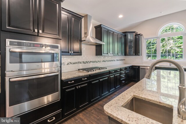 8266 Saint Francis Dr, Severn, MD 21144 - kitchen with stainless steel appliances, wall chimney range hood, tasteful backsplash, dark wood-style floors, and light stone counters