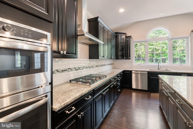 8266 Saint Francis Dr, Severn, MD 21144 - kitchen featuring stainless steel appliances, wall chimney exhaust hood, dark wood finished floors, decorative backsplash, and light stone countertops