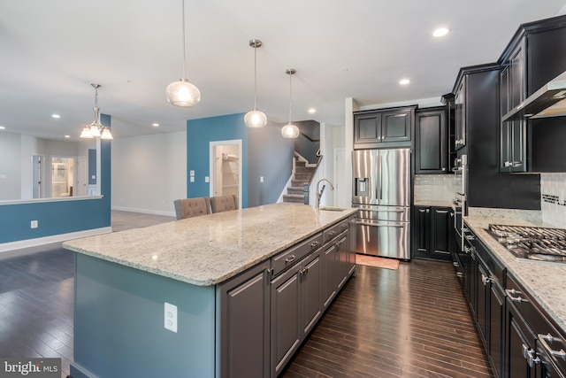 8266 Saint Francis Dr, Severn, MD 21144 - kitchen featuring stainless steel appliances, dark wood-style floors, tasteful backsplash, a kitchen island with sink, and wall chimney range hood