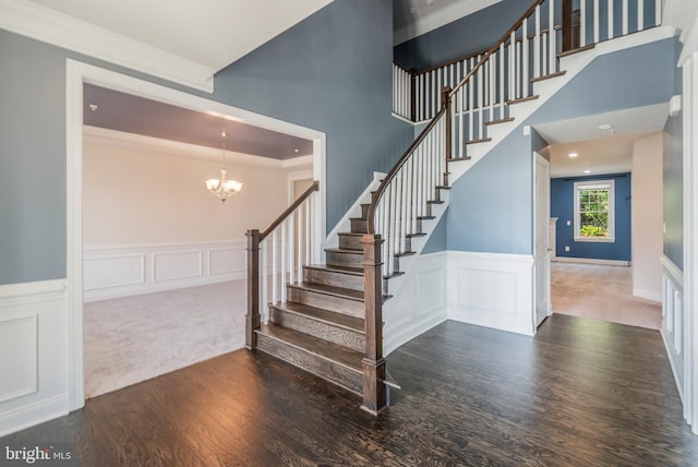8266 Saint Francis Dr, Severn, MD 21144 - stairway with a decorative wall, wood finished floors, a chandelier, wainscoting, and ornamental molding