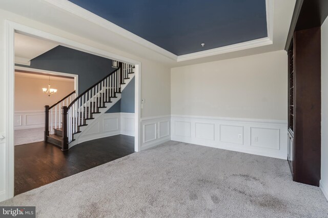 8266 Saint Francis Dr, Severn, MD 21144 - carpeted empty room with stairway, a raised ceiling, a chandelier, a decorative wall, and wainscoting
