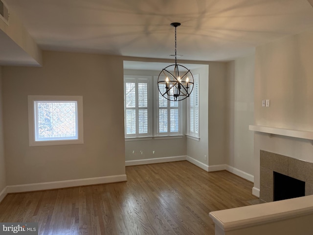 1423 T St NW, Washington, DC 20009 - unfurnished living room featuring a chandelier, healthy amount of natural light, wood finished floors, and a tiled fireplace