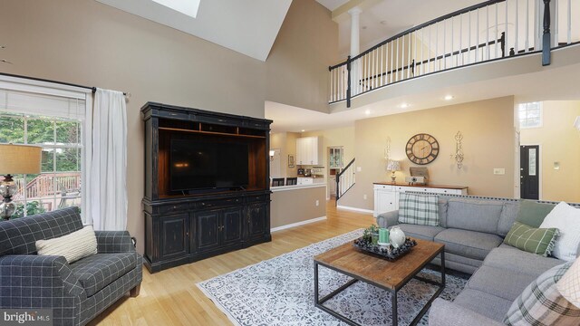 24 Montfort Dr, Belle Mead, NJ 08502 - living area featuring light wood finished floors, a high ceiling, a skylight, and ornate columns