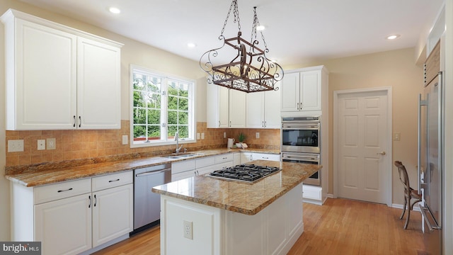 24 Montfort Dr, Belle Mead, NJ 08502 - kitchen with appliances with stainless steel finishes, a chandelier, light wood-type flooring, white cabinetry, and tasteful backsplash