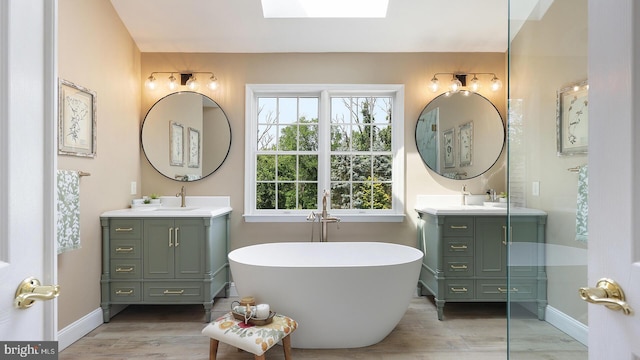 24 Montfort Dr, Belle Mead, NJ 08502 - full bathroom with a skylight, two vanities, a freestanding bath, and wood finished floors