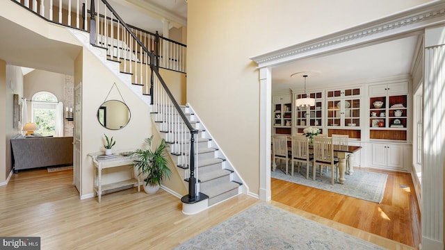 24 Montfort Dr, Belle Mead, NJ 08502 - stairs featuring wood finished floors, a chandelier, a towering ceiling, and crown molding