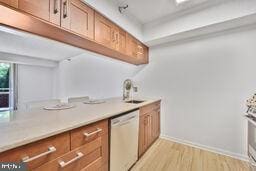 5802 Nicholson Ln Unit 2-L05, Rockville, MD 20852 - kitchen with dishwashing machine, brown cabinetry, light wood finished floors, and light countertops