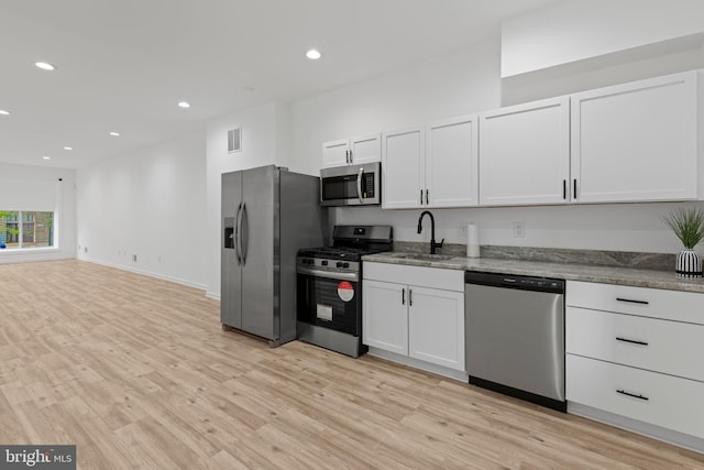 1804 E Lafayette Ave, Baltimore, MD 21213 - kitchen featuring stainless steel appliances, light wood-style flooring, recessed lighting, white cabinets, and light stone counters