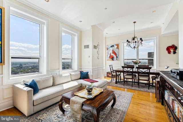 1425 Locust St Unit 33A, Philadelphia, PA 19102 - living room featuring crown molding, healthy amount of natural light, a chandelier, light wood-type flooring, and wainscoting