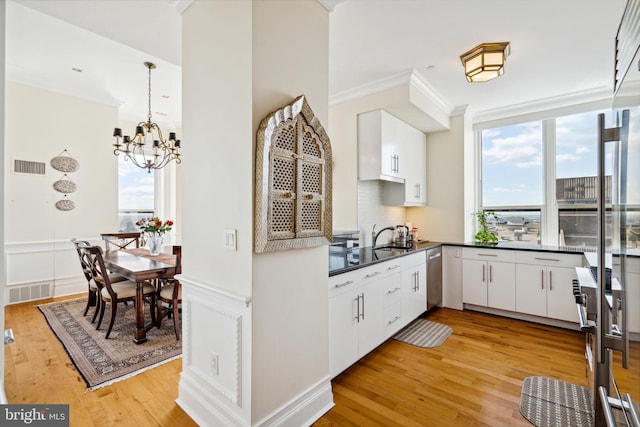 1425 Locust St Unit 33A, Philadelphia, PA 19102 - kitchen with dark countertops, a chandelier, light wood-type flooring, white cabinetry, and stainless steel dishwasher