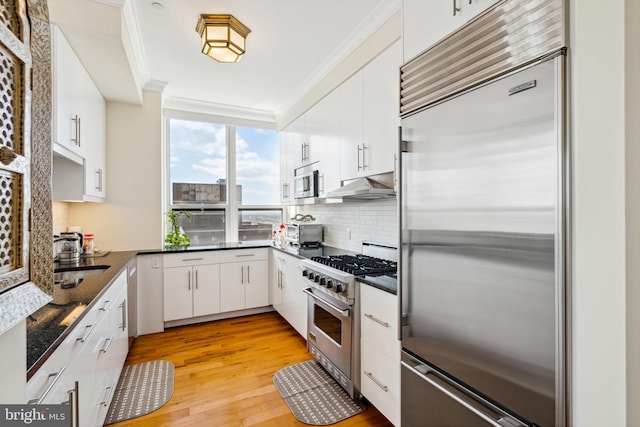 1425 Locust St Unit 33A, Philadelphia, PA 19102 - kitchen with premium appliances, crown molding, decorative backsplash, white cabinets, and light wood finished floors