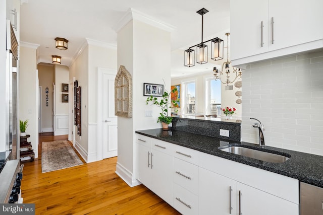 1425 Locust St Unit 33A, Philadelphia, PA 19102 - kitchen with backsplash, crown molding, light wood-type flooring, white cabinetry, and dark stone countertops