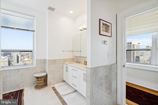 1425 Locust St Unit 33A, Philadelphia, PA 19102 - bathroom with tile walls, vanity, tile patterned floors, and a wainscoted wall