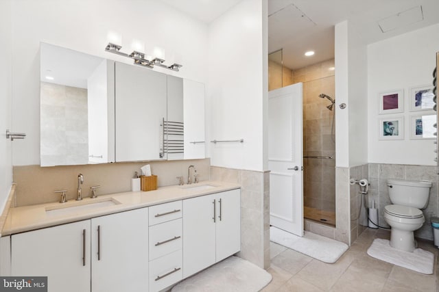 1425 Locust St Unit 33A, Philadelphia, PA 19102 - bathroom featuring tile walls, tile patterned floors, a walk in shower, double vanity, and a wainscoted wall