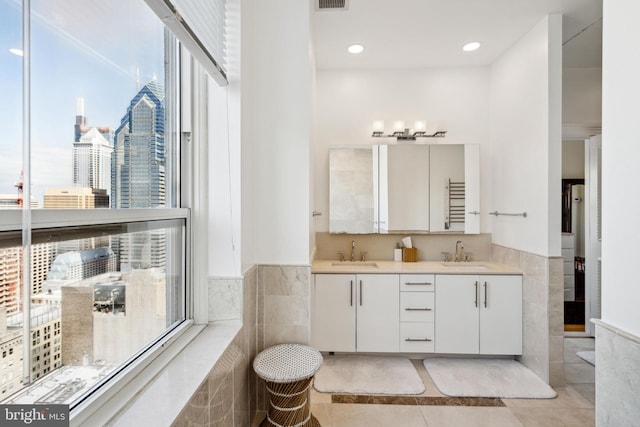 1425 Locust St Unit 33A, Philadelphia, PA 19102 - bathroom featuring tile patterned floors, double vanity, wainscoting, tile walls, and a city view