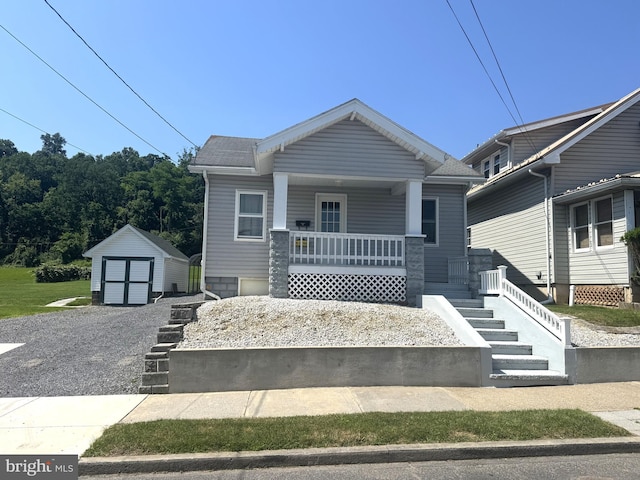 505 W 5th St, Lewistown, PA 17044 - view of front of house with a porch, a shed, gravel driveway, stairway, and a detached garage