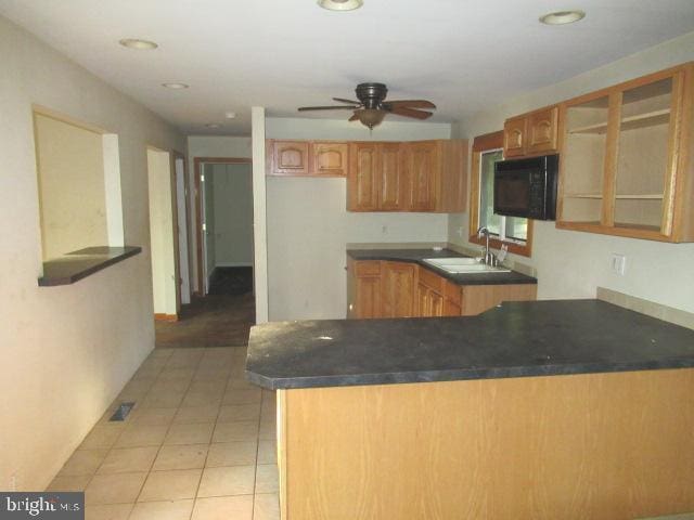 830 Jarvis Rd, Sicklerville, NJ 08081 - kitchen featuring black microwave, a peninsula, glass insert cabinets, ceiling fan, and brown cabinetry