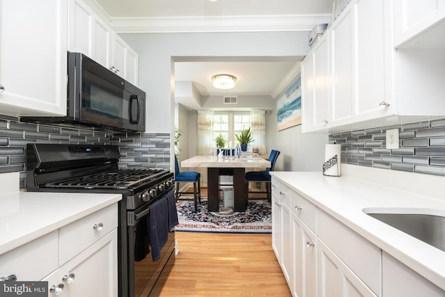 7093 Spring Garden Dr Unit 202, Springfield, VA 22150 - kitchen with black appliances, light wood-style flooring, white cabinets, light countertops, and tasteful backsplash