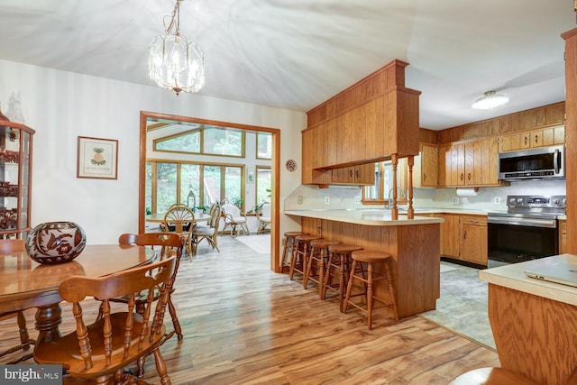 331 Spring Garden St, Ephrata, PA 17522 - kitchen featuring appliances with stainless steel finishes, light countertops, light wood-type flooring, a peninsula, and backsplash