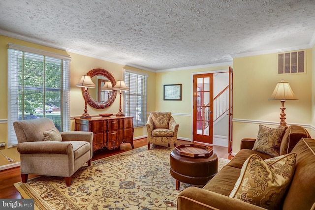 20304 Watkins Meadow Dr, Germantown, MD 20876 - living room featuring plenty of natural light, wood finished floors, a textured ceiling, ornamental molding, and stairs
