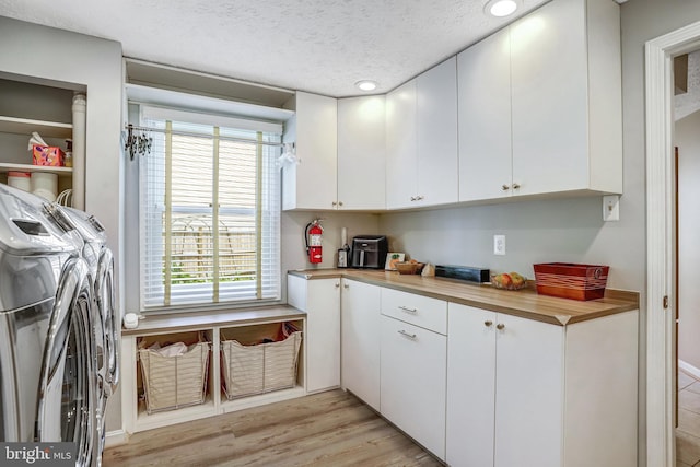 20304 Watkins Meadow Dr, Germantown, MD 20876 - laundry area with cabinet space, independent washer and dryer, recessed lighting, light wood finished floors, and a textured ceiling