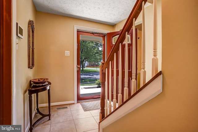 20304 Watkins Meadow Dr, Germantown, MD 20876 - foyer featuring a textured ceiling, light tile patterned flooring, and stairway