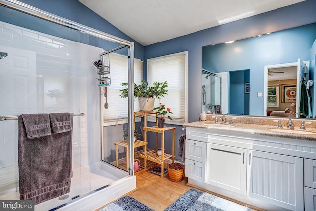 20304 Watkins Meadow Dr, Germantown, MD 20876 - bathroom with lofted ceiling, a stall shower, double vanity, and wood finished floors