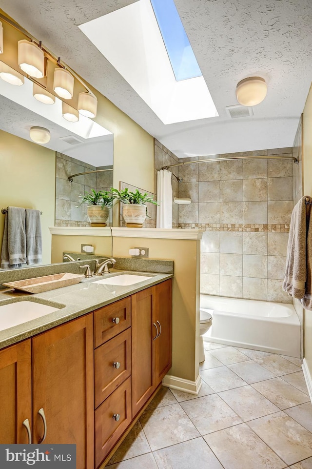 20304 Watkins Meadow Dr, Germantown, MD 20876 - full bathroom featuring a skylight, tile patterned floors, vanity, shower / tub combo with curtain, and a textured ceiling