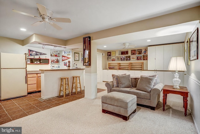 20304 Watkins Meadow Dr, Germantown, MD 20876 - carpeted living area featuring bar with sink, a ceiling fan, recessed lighting, tile patterned floors, and a wainscoted wall