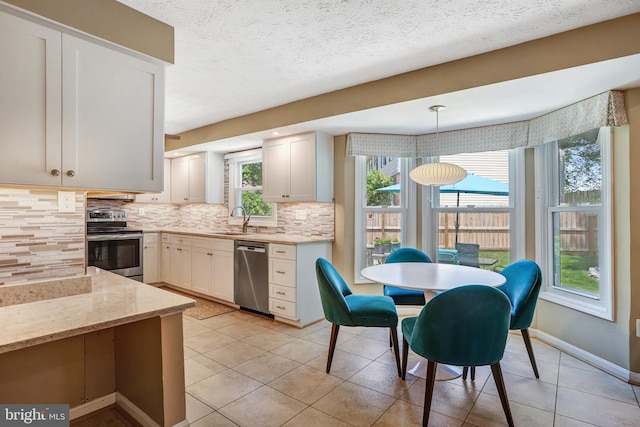 20304 Watkins Meadow Dr, Germantown, MD 20876 - kitchen with appliances with stainless steel finishes, decorative backsplash, light stone countertops, light tile patterned flooring, and white cabinetry
