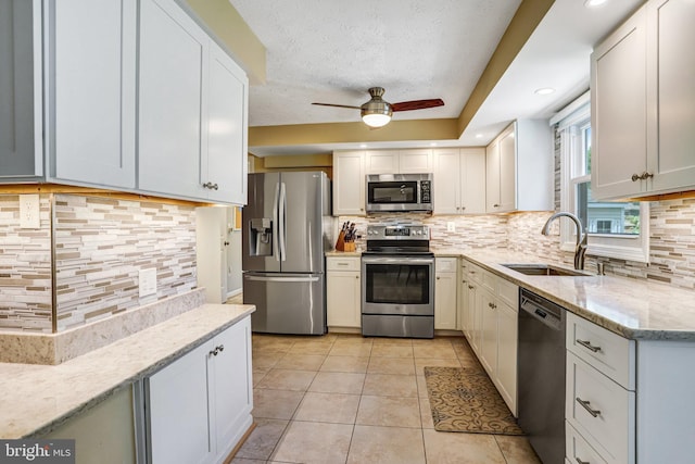 20304 Watkins Meadow Dr, Germantown, MD 20876 - kitchen with appliances with stainless steel finishes, backsplash, a ceiling fan, light stone counters, and light tile patterned flooring