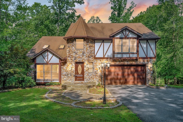 5599 Small Oak Ct, Woodbridge, VA 22192 - tudor-style house with stone siding, a garage, driveway, a lawn, and roof with shingles