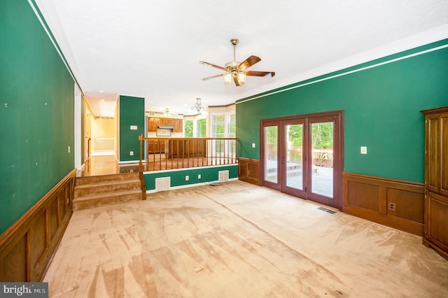 5599 Small Oak Ct, Woodbridge, VA 22192 - unfurnished living room featuring wainscoting, ceiling fan, french doors, a decorative wall, and carpet floors