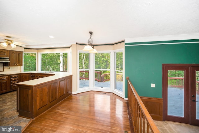 5599 Small Oak Ct, Woodbridge, VA 22192 - kitchen with a peninsula, light countertops, crown molding, a ceiling fan, and wood finished floors