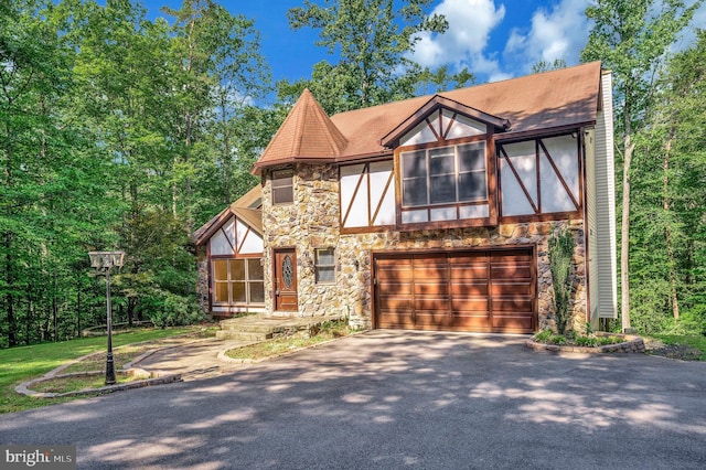 5599 Small Oak Ct, Woodbridge, VA 22192 - tudor home with stone siding, asphalt driveway, an attached garage, and roof with shingles