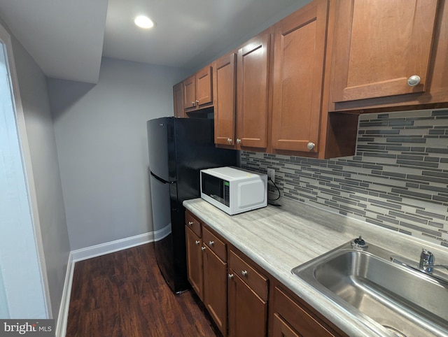 1625 Spruce, Baltimore City, MD 21226 - kitchen with white microwave, backsplash, light countertops, dark wood-style floors, and freestanding refrigerator