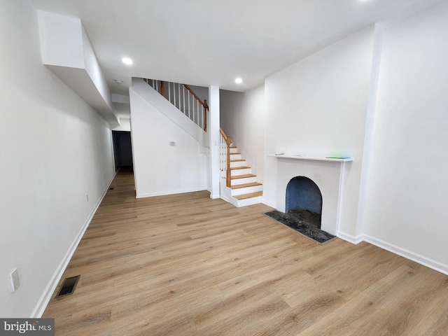 1703 Baker St, Baltimore, MD 21217 - unfurnished living room with wood finished floors, stairs, recessed lighting, and a fireplace