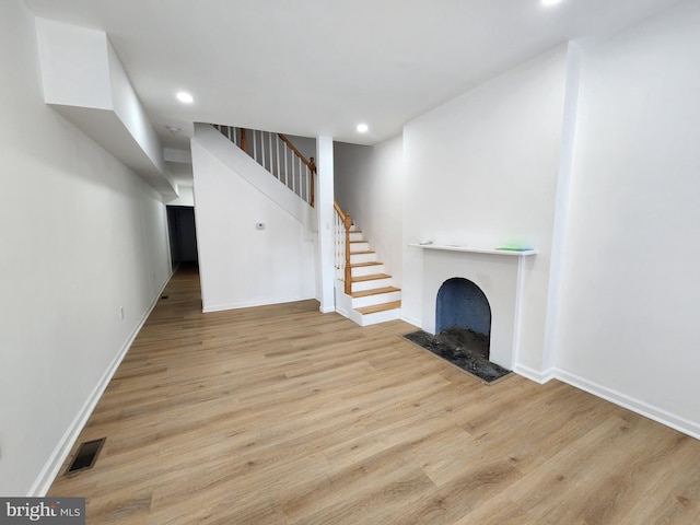 1703 Baker St, Baltimore, MD 21217 - unfurnished living room with wood finished floors, stairway, recessed lighting, and a fireplace