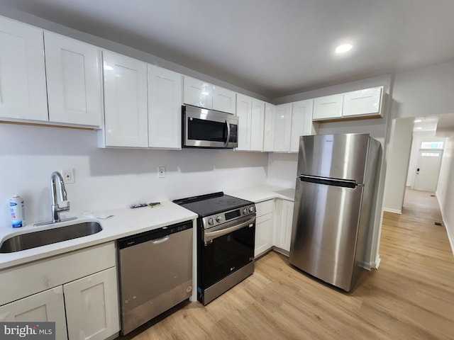 1703 Baker St, Baltimore, MD 21217 - kitchen with appliances with stainless steel finishes, light wood-style floors, light countertops, white cabinetry, and recessed lighting
