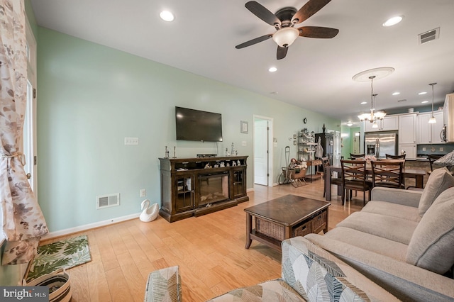 147 Candor Ln, Dover, DE 19901 - living area with ceiling fan, light wood-style flooring, a chandelier, recessed lighting, and a glass covered fireplace
