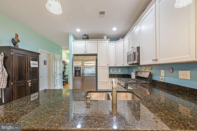 147 Candor Ln, Dover, DE 19901 - kitchen with stainless steel appliances, white cabinetry, recessed lighting, and dark stone counters