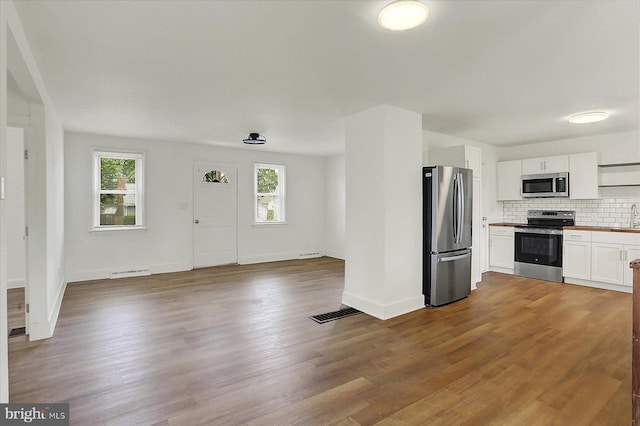 522 E Simpson St, Mechanicsburg, PA 17055 - kitchen with stainless steel appliances, tasteful backsplash, white cabinets, open floor plan, and wood finished floors
